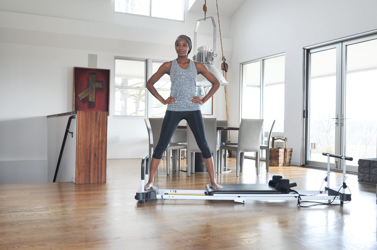 Woman using pilates reformer in the living room of her home h