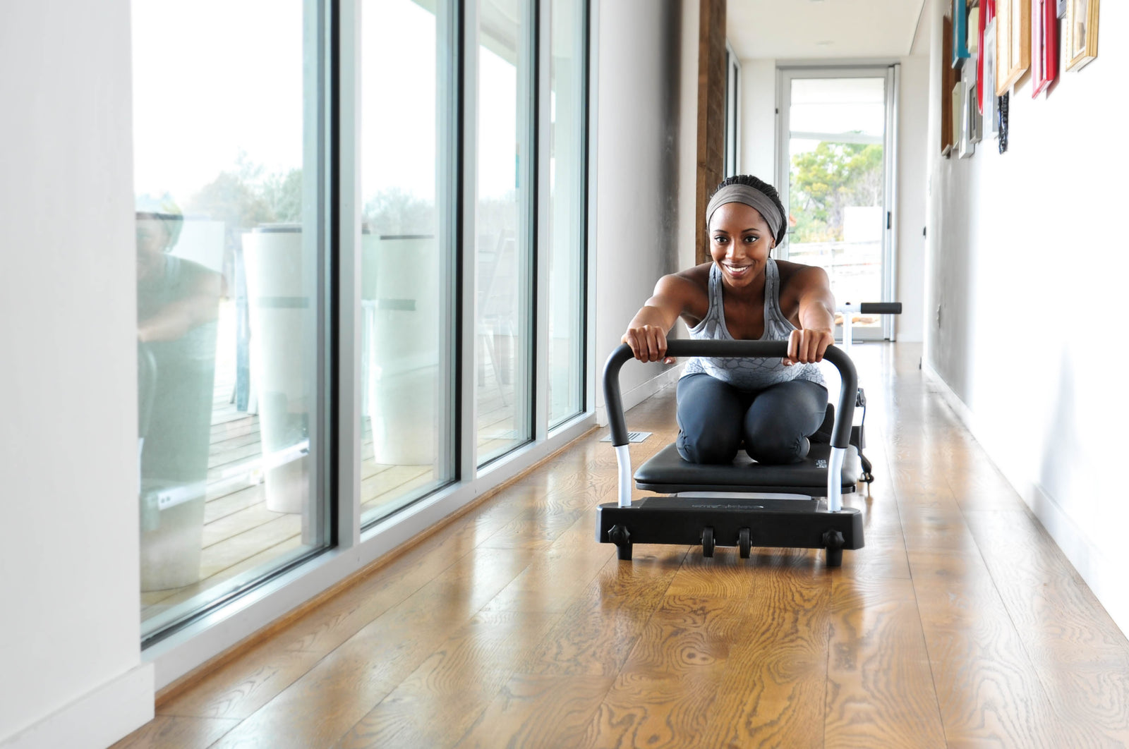Woman using pilates reformer machine at home